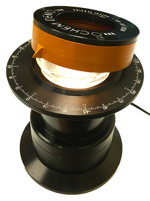 Labeled diagram of the polarimeter: top cap pointer, aluminum body, sample chamber with protractor, light source, beaker